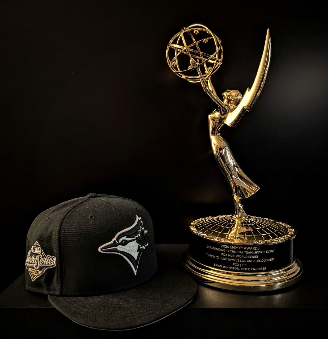 The 2026 Sports Emmy statuette beside a 2025 World Series Toronto Blue Jays cap